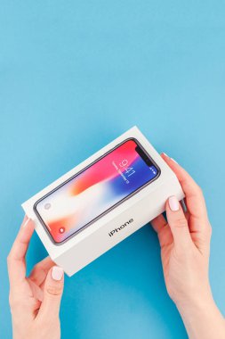 Berlin, Almanya - 24 Mayıs 2018: parlak mavi arka planı renkli kutuyu son Apple iphone X 10 akıllı telefon holding kadın eller. Unboxing kavramı kopya alanı ile