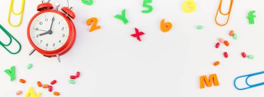 Beyaz masa arka plan kopya alanı, çerçeve, metin veya tasarım şablonu ile üzerinde uzun geniş afiş geri okul kavramı çalar saat, renk okul ve ofis malzemeleri