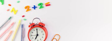 Beyaz masa arka plan kopya alanı, çerçeve, metin veya tasarım şablonu ile üzerinde uzun geniş afiş geri okul kavramı çalar saat, renk okul ve ofis malzemeleri