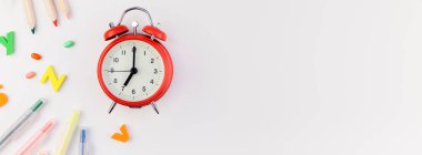 Beyaz masa arka plan kopya alanı, çerçeve, metin veya tasarım şablonu ile üzerinde uzun geniş afiş geri okul kavramı çalar saat, renk okul ve ofis malzemeleri
