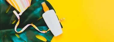 Tropikal orman palm monstera yaprak, güneş koruyucu boş şişe mockup ve parlak sarı Kağıt arka plan üzerinde mayo. 