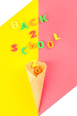 Yaratıcı düz parlak sarı ve pembe Kağıt arka plan üzerinde gözleme koni ve mektup mesaj ile okul kavramı geri yattı