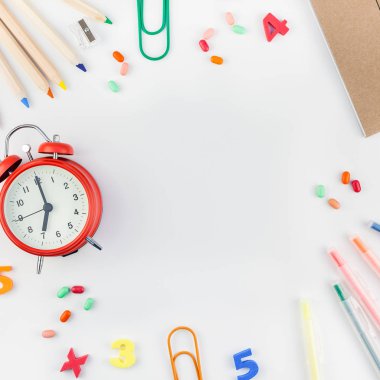 Kare düz geri okul kavramı çalar saat, renk okul ve ofis malzemeleri beyaz masa arka plan kopya alanı, çerçeve, metin veya tasarım şablonu ile yattı