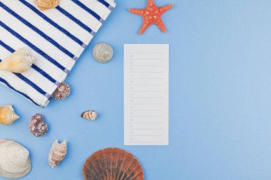 Yaratıcı düz yaz seyahat tatil kavramı yatıyordu. Kopya alanı en az tarzı, metin için şablon pastel mavi zemin üzerine plaj havlusu ve kabukları ve denizyıldızı Üstten Görünüm