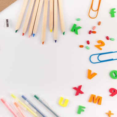 Kare düz geri okul kavramı kopya alanı, çerçeve, metin veya tasarım şablonu ile beyaz masa arka plan üzerinde renkli okul ve ofis malzemeleri ile yattı