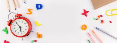 Beyaz masa arka plan kopya alanı, çerçeve, metin veya tasarım şablonu ile üzerinde uzun geniş afiş geri okul kavramı çalar saat, renk okul ve ofis malzemeleri