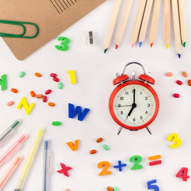 Kare düz geri okul kavramı çalar saat, renk okul ve ofis malzemeleri beyaz masa arka plan kopya alanı, çerçeve, metin veya tasarım şablonu ile yattı