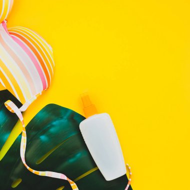 Tropikal orman palm monstera bırakır, güneş gözlüğü, Güneş kremi boş şişe mockup ve kadının mayo üstüne parlak kare Kağıt arka plan sarı. Yaz tatil yaratıcı düz yatıyordu kavramı şablonu