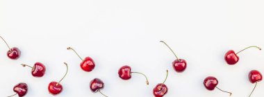 Minimal tarzda beyaz arka plan üzerinde izole kopya alanı ile taze olgun kiraz desen düzeninin uzun geniş afiş. Yaz eğlenceli ve sağlıklı beslenme kavramı. Metin veya gıda tasarımınız için şablon