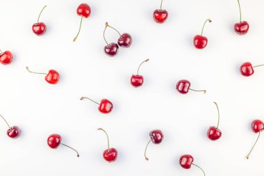 Minimal tarzda beyaz arka plan üzerinde izole kopya alanı ile taze olgun kiraz desen düzeninin yaratıcı üstten görünüm. Yaz eğlenceli ve sağlıklı beslenme kavramı. Metin veya gıda tasarımınız için şablon