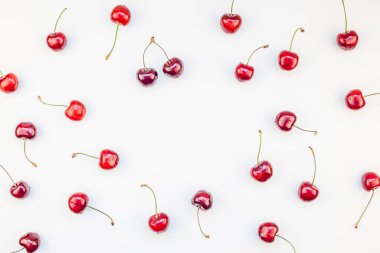 Minimal tarzda beyaz arka plan üzerinde izole kopya alanı ile taze olgun kiraz desen düzeninin yaratıcı üstten görünüm. Yaz eğlenceli ve sağlıklı beslenme kavramı. Metin veya gıda tasarımınız için şablon