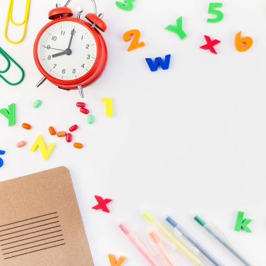 Kare düz geri okul kavramı çalar saat, renk okul ve ofis malzemeleri beyaz masa arka plan kopya alanı, çerçeve, metin veya tasarım şablonu ile yattı