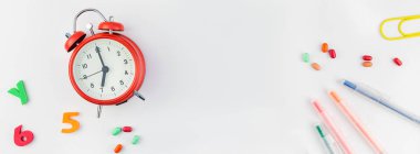 Beyaz masa arka plan kopya alanı, çerçeve, metin veya tasarım şablonu ile üzerinde uzun geniş afiş geri okul kavramı çalar saat, renk okul ve ofis malzemeleri