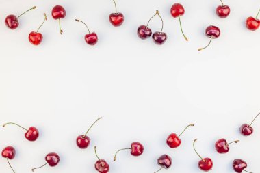Minimal tarzda beyaz arka plan üzerinde izole kopya alanı ile taze olgun kiraz desen düzeninin yaratıcı üstten görünüm. Yaz eğlenceli ve sağlıklı beslenme kavramı. Metin veya gıda tasarımınız için şablon