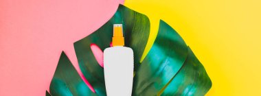 Tropikal orman palmiye monstera yaprakları ve güneş koruyucu boş şişe mockup parlak sarı ve pembe çift ton kağıt arka plan üzerinde. Yaz yaratıcı düz yatıyordu kavramı Şablon metnini tatiller. Uzun geniş afiş