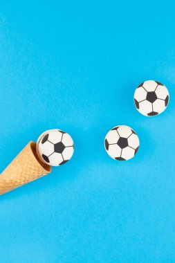 Yaratıcı düz dondurma waffle koniler en iyi görünümü ile futbol topları macarons kopya alanı en az tarzı, Çocuk Doğum günü için futbol oyunları kavramı ile parlak kalın mavi arka plan üzerinde göklere