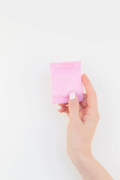コピー スペースで白い背景に分離されたピンクの毎日生理用ナプキンを保持しているパステル カラー マニキュア ポーランド語で女性の手 女性の美しさのブログのソーシャル メディアのテンプレートです 女性のヘルスケアの概念 — ストック写真