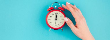Yaratıcı düz yatıyordu kavramı kırmızı vintage çalar saat parlak mavi turkuaz üzerinde tutan kadın el üst görünümünü renk Kağıt arka plan kopya alanı ile minimal tarzda uzun geniş afiş