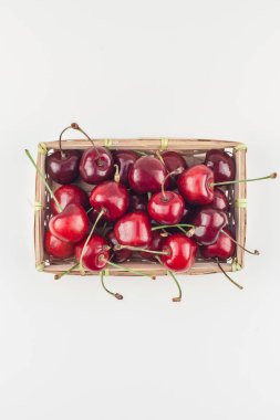 Yaratıcı üstten görünüm taze olgun kiraz kopya alanı ile küçük bir sepet içinde beyaz arka plan en az stili izole. Yaz eğlenceli ve sağlıklı beslenme kavramı. Metin veya gıda tasarımınız için şablon