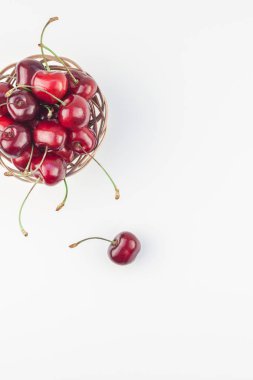 Yaratıcı üstten görünüm taze olgun kiraz kopya alanı ile küçük bir sepet içinde beyaz arka plan en az stili izole. Yaz eğlenceli ve sağlıklı beslenme kavramı. Metin veya gıda tasarımınız için şablon