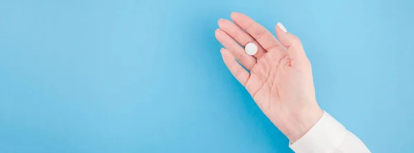 Mano Mujer Sosteniendo Una Píldora Blanca Sobre Fondo Papel Azul —  Fotos de Stock