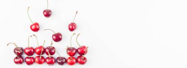 Minimal tarzda beyaz arka plan üzerinde izole kopya alanı ile taze olgun kiraz desen düzeninin uzun geniş afiş. Yaz eğlenceli ve sağlıklı beslenme kavramı. Metin veya gıda tasarımınız için şablon