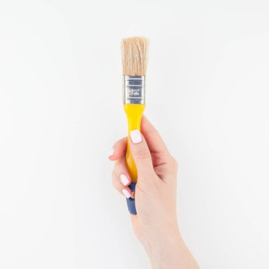 Kare görüntü yeni boya fırçası ile minimalizm tarzı beyaz arka plan üzerinde izole kopya yer tutan kadın el. Kadınsı blog, sosyal medya için şablon. Onarım veya iyileştirme kavramı