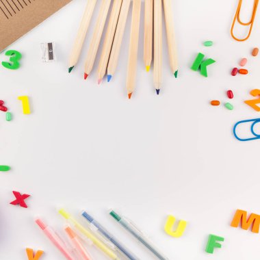 Kare düz geri okul kavramı kopya alanı, çerçeve, metin veya tasarım şablonu ile beyaz masa arka plan üzerinde renkli okul ve ofis malzemeleri ile yattı