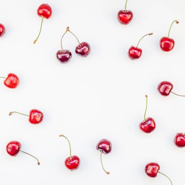Üstten görünüm taze olgun kiraz desen düzeninin en az tarzında beyaz arka plan üzerinde izole kopya alanı ile kare. Yaz eğlenceli ve sağlıklı beslenme kavramı. Metin veya gıda tasarımınız için şablon