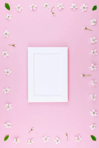 创意平躺概念空白框架模拟和樱桃树花在柔和的千禧年粉红色背景与复制空间最小的风格 文字或设计模板 — 图库照片