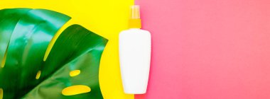 Tropikal orman palmiye monstera yaprakları ve güneş koruyucu boş şişe mockup parlak sarı ve pembe çift ton kağıt arka plan üzerinde. Yaz yaratıcı düz yatıyordu kavramı Şablon metnini tatiller. Uzun geniş afiş