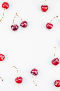 Minimal tarzda beyaz arka plan üzerinde izole kopya alanı ile taze olgun kiraz desen düzeninin yaratıcı üstten görünüm. Yaz eğlenceli ve sağlıklı beslenme kavramı. Metin veya gıda tasarımınız için şablon