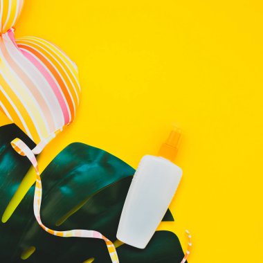 Tropikal orman palm monstera bırakır, güneş gözlüğü, Güneş kremi boş şişe mockup ve kadının mayo üstüne parlak kare Kağıt arka plan sarı. Yaz tatil yaratıcı düz yatıyordu kavramı şablonu