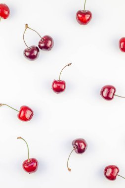 Minimal tarzda beyaz arka plan üzerinde izole kopya alanı ile taze olgun kiraz desen düzeninin yaratıcı üstten görünüm. Yaz eğlenceli ve sağlıklı beslenme kavramı. Metin veya gıda tasarımınız için şablon