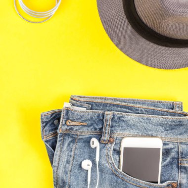 Düz Süet ayakkabı, kot, kalın sarı Kağıt arka plan gri şapka, kaktüs ve akıllı telefon kulaklık kopya alanı ile yatıyordu. Kadın rahat kıyafet havai görünümü. Kare hipster bak üstten görünüm