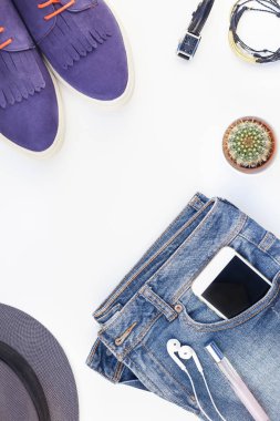 Düz beyaz arka plan kopya alanı ile kulaklıktan süet ayakkabı, kot, gri şapka, kaktüs ve akıllı telefon yatırın. Kadın rahat kıyafet havai görünümü. Trendy hipster bak üstten görünüm