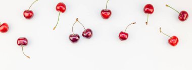 Minimal tarzda beyaz arka plan üzerinde izole kopya alanı ile taze olgun kiraz desen düzeninin uzun geniş afiş. Yaz eğlenceli ve sağlıklı beslenme kavramı. Metin veya gıda tasarımınız için şablon