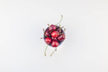 Taze olgun kiraz bir kase minimal tarzda beyaz arka plan üzerinde izole kopya alanı ile yaratıcı üstten görünüm. Yaz eğlenceli ve sağlıklı beslenme kavramı. Metin veya gıda tasarımınız için şablon