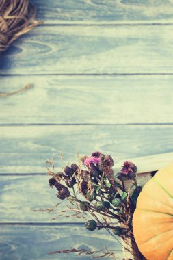 Sonbahar turuncu kabak ve Kuru çiçekler görünümünü ana sayfa ve kopya alanı ile mavi tonda ahşap masa üzerinde kutusu Şükran günü arka planda çim. Sonbaharda hasat ruh metin için şablon