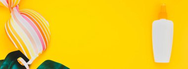 Tropikal orman palm monstera, güneş koruyucu boş şişe mockup ve kadının mayo parlak sarı Kağıt arka plan üzerinde bırakır. Yaz yaratıcı düz yatıyordu kavramı Şablon metnini tatiller. Uzun geniş afiş