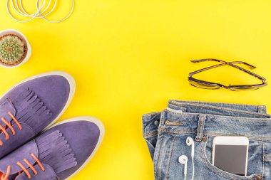 Düz Süet ayakkabı, kot, kalın sarı Kağıt arka plan gri şapka, kaktüs ve akıllı telefon kulaklık kopya alanı ile yatıyordu. Kadın rahat kıyafet havai görünümü. Trendy hipster bak üstten görünüm