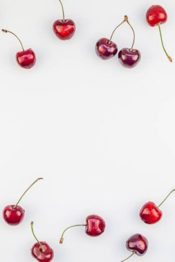 Minimal tarzda beyaz arka plan üzerinde izole kopya alanı ile taze olgun kiraz desen düzeninin yaratıcı üstten görünüm. Yaz eğlenceli ve sağlıklı beslenme kavramı. Metin veya gıda tasarımınız için şablon
