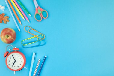 Yaratıcı düz yatıyordu üstten görünüm geri okul kavramı çalar saat, renk okul ve ofis malzemeleri parlak turkuaz kağıt tablo çerçeve arka plan kopya alanı, metin veya tasarım şablonu ile