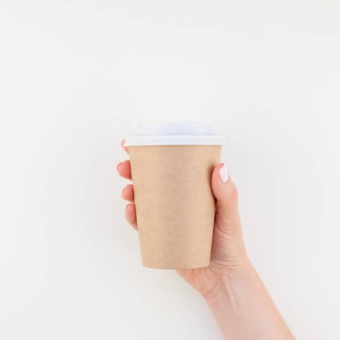 Görüntü craft kağıt kahve Kupası minimalizm tarzı beyaz arka plan üzerinde izole kopya alanı ile tutan kadın el kadar alay Meydanı. Kadınsı blog, sosyal medya için şablon
