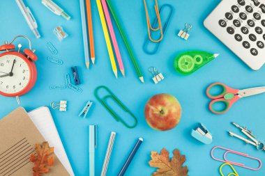 Yaratıcı düz yatıyordu üstten görünüm geri okul kavramı çalar saat, renk okul ve ofis malzemeleri parlak turkuaz kağıt tablo çerçeve arka plan kopya alanı, metin veya tasarım şablonu ile