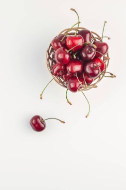 Yaratıcı üstten görünüm taze olgun kiraz kopya alanı ile küçük bir sepet içinde beyaz arka plan en az stili izole. Yaz eğlenceli ve sağlıklı beslenme kavramı. Metin veya gıda tasarımınız için şablon