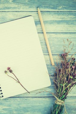 Üstten görünüm sonbahar turuncu kabak ve kuru çiçek çimen şükran günü arka plan üzerinde mavi ile defter sahte ile ahşap masa tonda ve rustik tarzı, metin için şablon alanı Kopyala