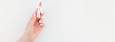 Kadın el ile pastel pembe ruj izole kopya alanı ile beyaz arka planda tutan Lehçe manikür. Uzun geniş afiş kadınsı güzellik blog sosyal medya için
