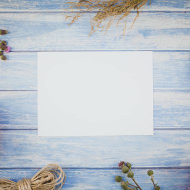 Çim arka plan ile sonbahar kuru çiçek üstten görünüm üzerinde mavi tonda ahşap masa boş mektup sahte ile kare ve rustik tarzı, metin için şablon alanı Kopyala