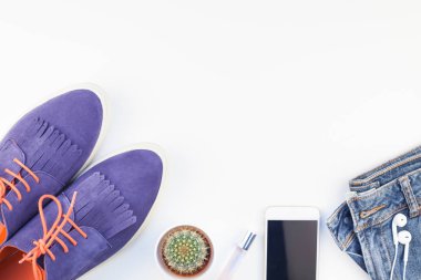 Düz beyaz arka plan kopya alanı ile kulaklıktan süet ayakkabı, kot, bilezik kaktüs ve akıllı telefon yatırın. Kadın rahat kıyafet havai görünümü. Trendy hipster bak üstten görünüm